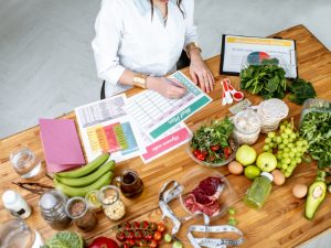 A nutritionist plans a balanced diet with fresh ingredients to optimise meal timing for better health outcomes.