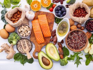 Healthy foods including salmon, avocado, nuts, and grains contrasted with worst foods for slow metabolism.