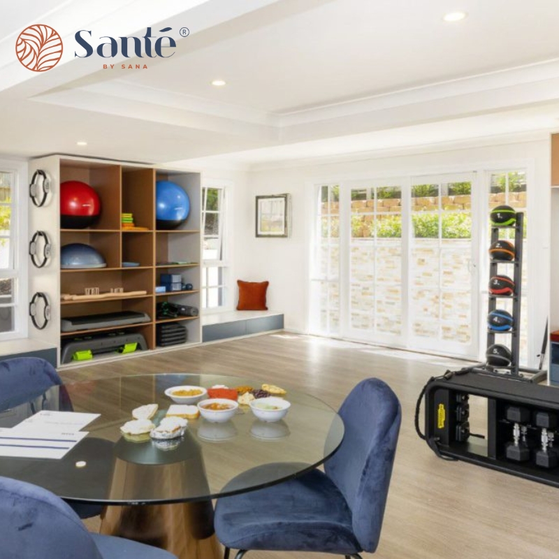 A well-equipped home gym featuring various exercise equipment and a table, designed for a weight loss clinic in Abbotsbury.